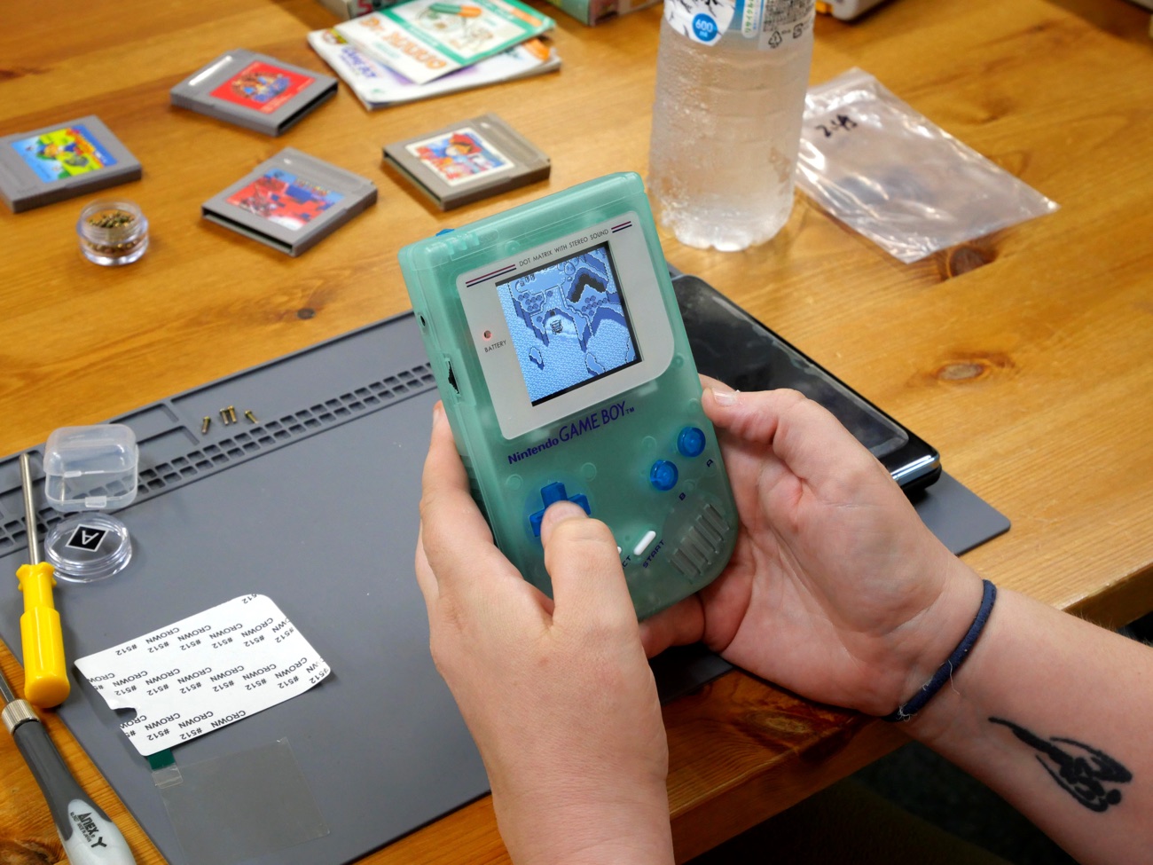 Mint Game Boy being played, screen lit
